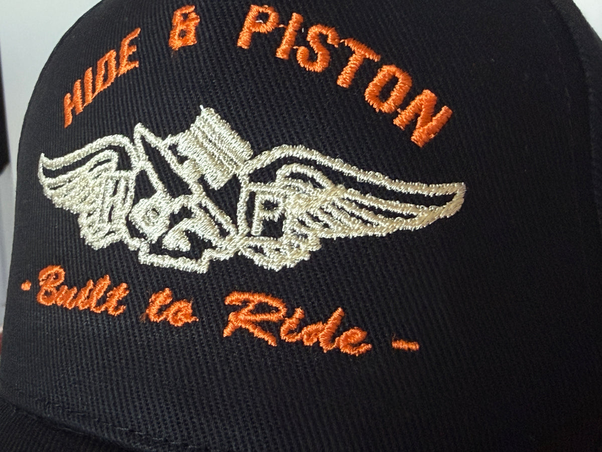 Close-up of Hide & Piston embroidered logo on black biker cap