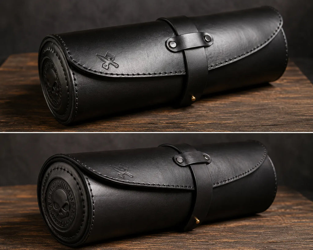 A black leather cylindrical roll-up case with a strap closure and metal rivets, shown from two angles on a dark wooden surface against a dark background.